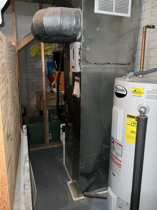 Conducted comprehensive assessment of existing HVAC system and found outdoor condensing unit exhibiting significant rust, corrosion, and refrigerant loss. Presented replacement system options to customer and documented current equipment condition including furnace, water heater, and associated ductwork in basement utility area.