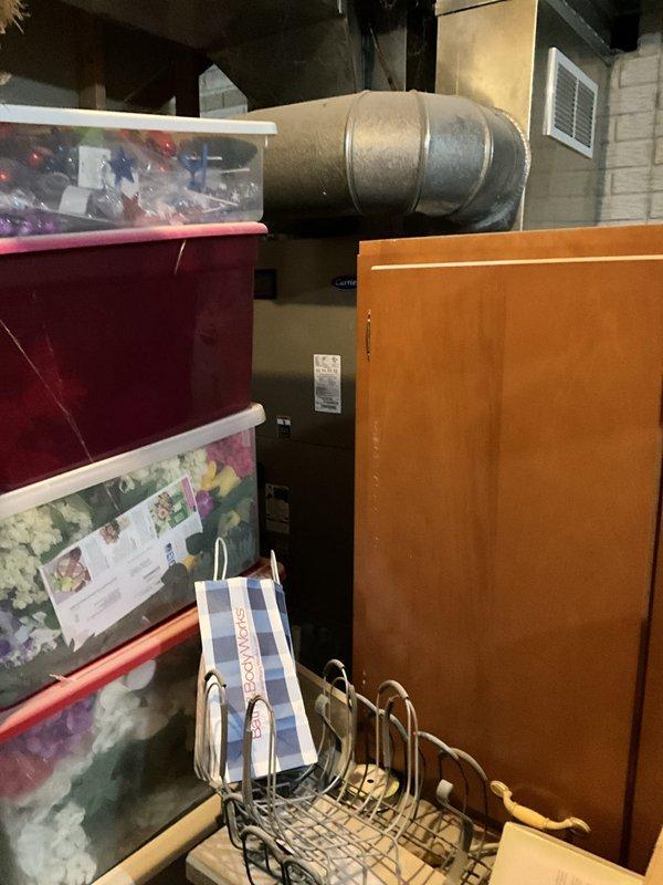 Conducted comprehensive assessment of existing HVAC system and found outdoor condensing unit exhibiting significant rust, corrosion, and refrigerant loss. Presented replacement system options to customer and documented current equipment condition including furnace, water heater, and associated ductwork in basement utility area.