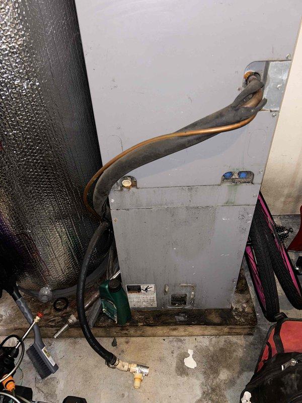 Responded to no cooling complaint and performed diagnostic evaluation of split system air conditioning unit. Inspected outdoor condenser unit and indoor air handler, documented refrigerant lines showing signs of corrosion and discoloration on piping. System components photographed for service records, including condenser unit positioned on concrete pad with louvered grilles and indoor air handler installation in mechanical room.