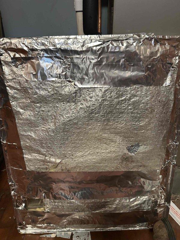 Responded to callback for unusual noise from indoor air handler unit following recent maintenance. Upon inspection, discovered deteriorated foil-faced insulation material had separated from ductwork and debris had entered the blower motor assembly. Removed insulation debris from motor housing and verified motor operation. Assessed condition of existing duct insulation, which showed extensive foil layer damage, tears, and separation from foam backing. Removed compromised insulation sections to prevent further contamination of system components. Unit tested and confirmed normal operation with no abnormal noise present at time of departure.