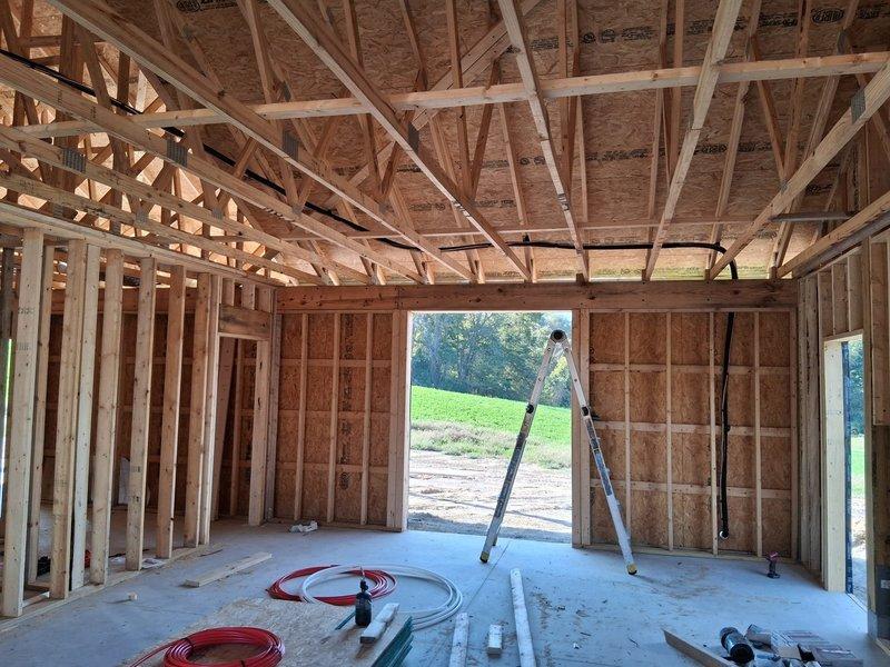 Completed HVAC rough-in installation for new construction project, including running refrigerant lineset from outdoor unit location to indoor air handler position. Installed sidewall flex duct return air system with proper collars and connections at framing stage. All ductwork and refrigerant lines positioned and secured according to building layout, ready for insulation and final connections once structure is enclosed.