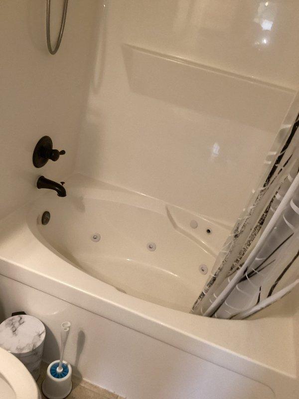 Completed monthly plumbing inspection for membership service. Performed comprehensive assessment of kitchen and bathroom plumbing fixtures, including garbage disposal unit under kitchen sink and jetted whirlpool tub with wall-mounted controls. Documented all visible plumbing connections, supply lines, drainage systems, and fixture conditions through photographic record for maintenance tracking purposes.