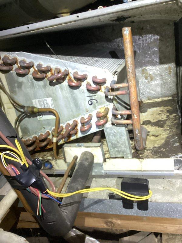 Completed annual heating maintenance on 11-year-old furnace system. Performed comprehensive tune-up including inspection of evaporator coil assembly, copper refrigerant lines, and ductwork components. Noted significant dust and debris accumulation on metal ductwork surfaces and HVAC components throughout system. Inspected evaporator coil with aluminum fins and U-bend copper tubing configuration, observing age-appropriate oxidation and patina on copper surfaces. Verified electrical connections and wiring integrity at air handler unit. All components found operational during inspection, with system showing normal wear patterns consistent with age and service history.
