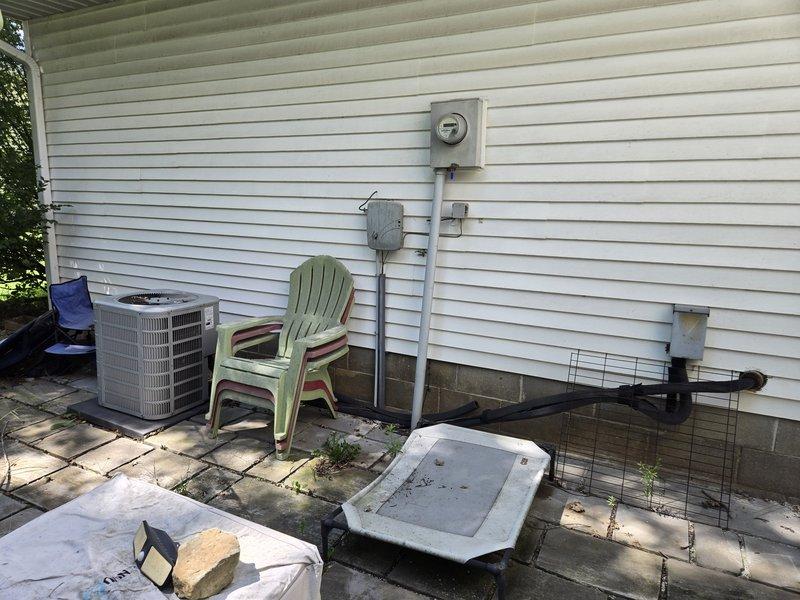 Conducted commercial HVAC site assessment and documented existing conditions. Measured clearance spacing between exterior AC condenser unit and building structure to verify compliance with manufacturer specifications and service access requirements. Photographed equipment placement, surrounding work area, and utility connections for service records and future reference.