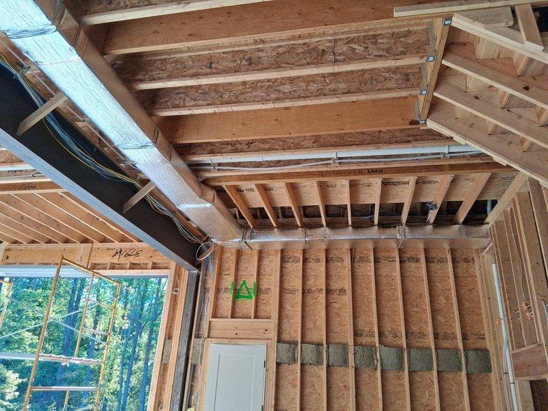 Completed three-day HVAC ducting rough-in at residential new construction site. Installed large-diameter supply trunk line with reflective insulation wrap, secured with proper strapping at code-compliant intervals throughout exposed ceiling joists. Routed flexible ductwork and rectangular metal duct runs through framed structure, coordinating with electrical and other trades to ensure proper clearances and support.