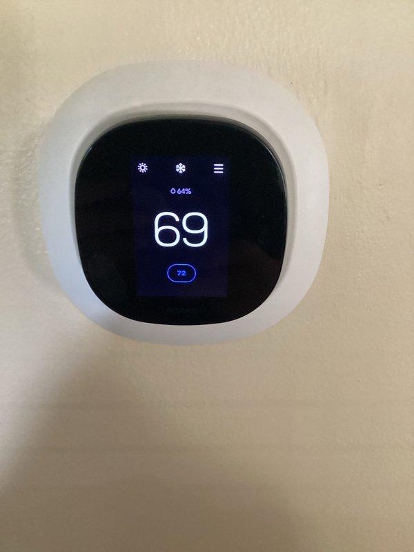 Completed monthly basic heating maintenance visit on residential HVAC system. Inspected 16x25x4 air filter housing and verified proper filter installation, observed thermostat operation displaying current temperature of 69°F with setpoint of 72°F in heating mode, and documented system components showing normal wear and dust accumulation on ductwork and filter housing area.