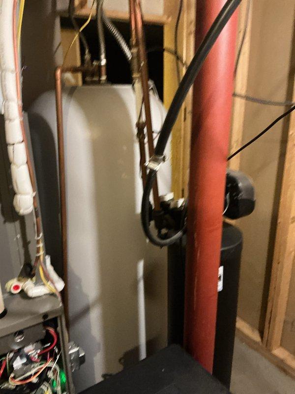 # HVAC Maintenance - Heating System Service

Completed annual heating maintenance visit on residential forced air system. Performed comprehensive inspection of furnace components including blower motor (FASCO unit visible during inspection), heat exchanger, burner assembly, and gas connections. Verified proper operation of all safety controls and limit switches.

Inspected mechanical room installation including water heater connections, copper supply lines, and associated plumbing infrastructure. Checked electrical connections at control panel and verified proper wire terminations. Examined gas piping, pressure tested system, and confirmed secure mounting of all components to wooden structural framing.

Tested furnace ignition sequence, flame sensor operation, and burner performance. Measured temperature rise across heat exchanger and confirmed within manufacturer specifications. Inspected flue pipe connections and verified proper venting. Checked condensate drain lines for blockages a