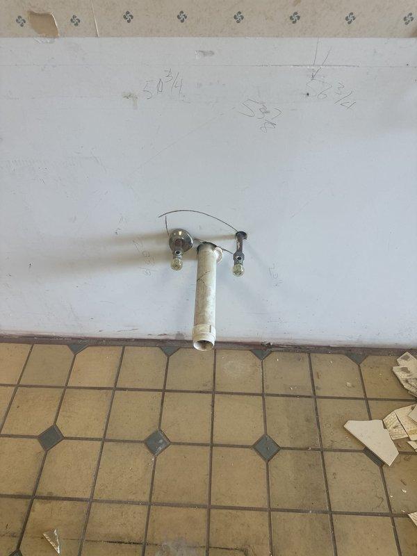 Conducted on-site assessment of existing plumbing infrastructure for water service modifications in grooming facility. Evaluated condition and functionality of current water supply lines to determine which lines could be safely removed and which remained serviceable for grooming tub connections. Inspected exposed piping in ceiling and wall penetrations, noting deteriorated conditions and water damage in surrounding areas. Documented existing pipe configurations, including protruding wall-mounted supply lines with T-fittings, to provide accurate estimate for line removal and system verification prior to grooming tub installation.