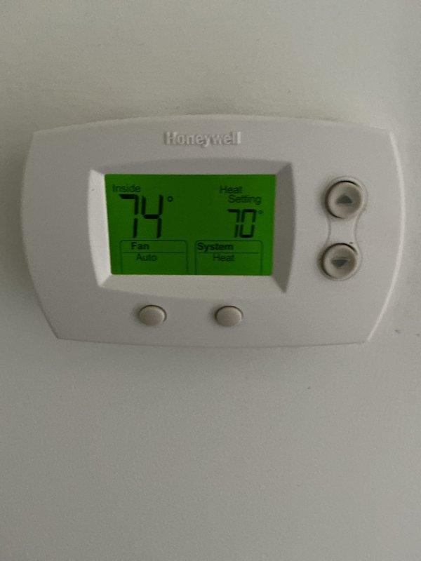 Performed scheduled monthly heating maintenance, replacing the 16x20x1 return air filter and verifying thermostat operation in Heat mode with the fan set to Auto (74° indoor reading, 70° setpoint). Inspected the blower assembly through the access opening, noting mineral deposits and light oxidation on the galvanized housing and surface cracking on the adjacent wiring, which should be monitored at future visits.