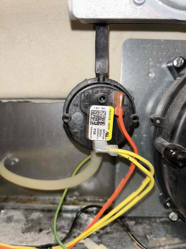 Responded to a reported slow water leak at the basement HVAC system (approximately 10-year-old AC and furnace) and confirmed the issue as HVAC-related rather than plumbing. Inspected the furnace cabinet and verified the Honeywell 1.65" WC pressure switch, including its mounting, wiring connections, and vacuum hose routing, with no visible corrosion or damage noted. Examined the cabinet for moisture sources associated with condensate drainage.