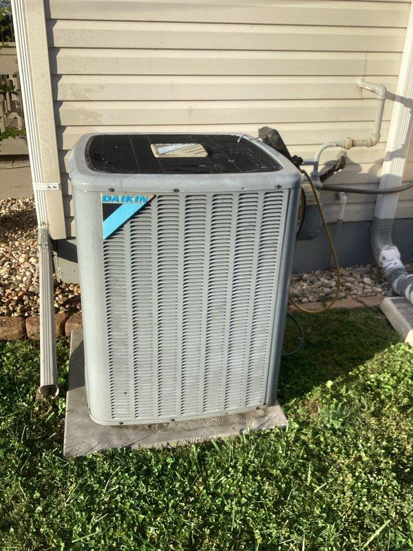 Performed diagnostic evaluation of the Daikin R410A split-system condenser in response to a suspected low refrigerant charge. Connected digital manifold gauges and recorded operating readings of 138.6 psig suction and 310.8 psig discharge, with 30.6°F superheat and 7.2°F subcooling. The condenser exterior showed no visible frost, ice, or leak indicators. Readings are consistent with a system operating below optimal charge, and further leak detection and charge correction are recommended.