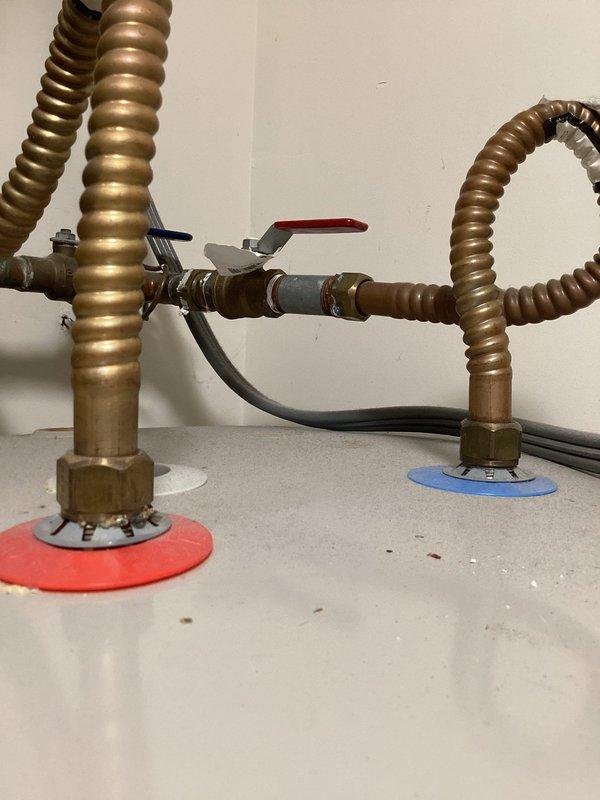 Performed an on-site assessment of the existing A.O. Smith ProMax electric water heater, documenting the tank, corrugated flexible water connectors, inlet/outlet shutoff valve assembly, and cord-and-plug electrical connection for replacement estimating. Fittings showed minor age-related tarnish with no visible leaks, rust, or damage. Also documented the garage panel and deep freeze area to evaluate routing for a dedicated circuit.