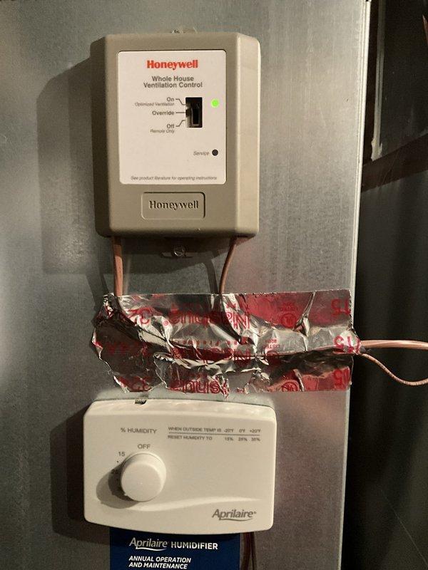 Performed an on-site evaluation for replacement of the existing heating system, including inspection of the associated ancillary equipment. Documented the Honeywell whole-house ventilation control and Aprilaire humidity control mounted on the supply duct, along with the exterior air conditioning condenser, which showed no visible frost, rust, or damage. Gathered system information to prepare a replacement estimate for the homeowner to compare against competing quotes.