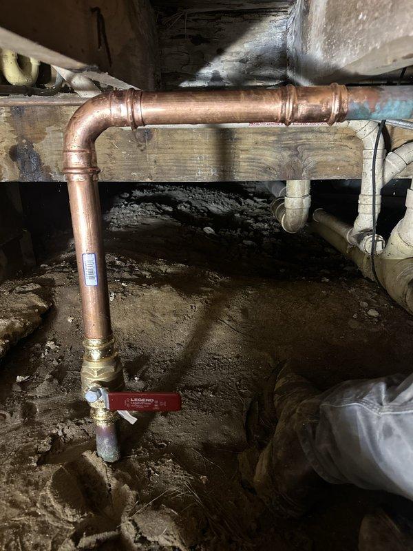Replaced the failed main water line shut-off valve in the crawl space, which was leaking at the tee fitting and showing heavy corrosion on the surrounding copper. Isolated the water supply, removed the compromised valve, and installed a new brass ball valve with press-style copper fittings. Pressure tested the connection and confirmed leak-free operation.