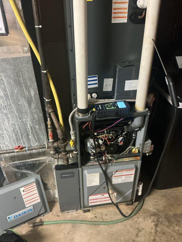 Performed monthly preventive maintenance inspection on a gas-fired Daikin furnace, removing the lower access panel to inspect the gas valve, blower motor, wiring harness, and Honeywell control module, and verifying operation with a digital meter. Checked gas piping, flexible connectors, shutoff valves, PVC condensate/vent piping, and ductwork connections for leaks or damage, with no frost, rust, or deficiencies noted. Visually inspected the adjacent A.O. Smith commercial water heater, including flue, gas connections, and piping, with no visible damage or issues; air filter replacement was not included in this visit.