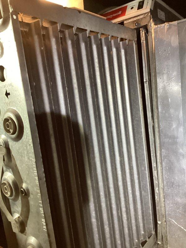 Performed annual heating system maintenance, inspecting the supply ductwork, damper assembly, linkage hardware, and control components for proper operation and airflow. Removed and inspected the metal mesh air filter, which showed heavy dust and debris loading, and documented the condition for filter cleaning or replacement to restore proper airflow. Verified all components were free of frost, ice, and corrosion, and completed the maintenance log entries.