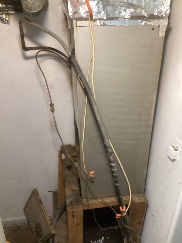 Responded to a no-cooling complaint and performed a full A/C system diagnostic, inspecting the vertical air handler, refrigerant line set, low-voltage and line-voltage wiring connections, and thermostat operation. Observed the thermostat calling for cooling (set to Cool, reading 79°) and noted deteriorated refrigerant line insulation and loose, unprotected wiring at the air handler, which are potential contributors to reduced cooling performance. Verified system operation following service and recommended replacing the worn suction line insulation and properly securing the electrical connections to prevent future issues.