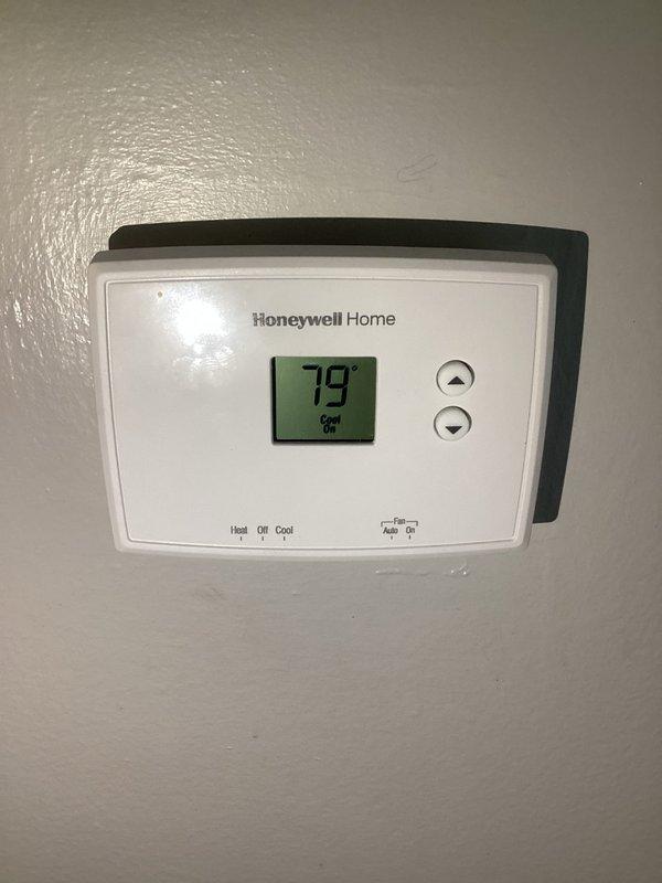 Responded to a no-cooling complaint and performed a full A/C system diagnostic, inspecting the vertical air handler, refrigerant line set, low-voltage and line-voltage wiring connections, and thermostat operation. Observed the thermostat calling for cooling (set to Cool, reading 79°) and noted deteriorated refrigerant line insulation and loose, unprotected wiring at the air handler, which are potential contributors to reduced cooling performance. Verified system operation following service and recommended replacing the worn suction line insulation and properly securing the electrical connections to prevent future issues.