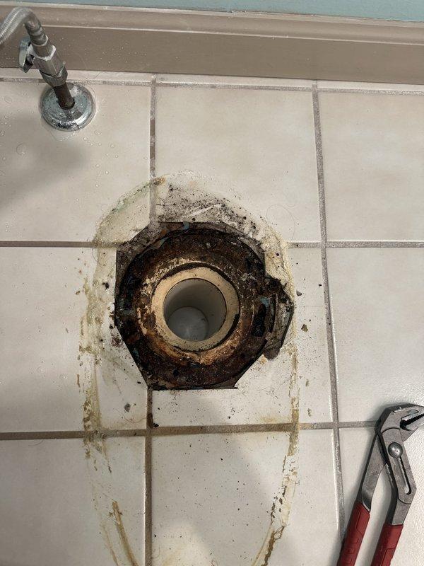 Removed the existing toilet and found a heavily corroded toilet flange with old wax residue and debris around the drain opening. Cleaned the flange area and installed the customer-supplied toilets with new wax seals and closet bolts, then reconnected the water supply lines, tested for proper flush operation, and confirmed no leaks.
