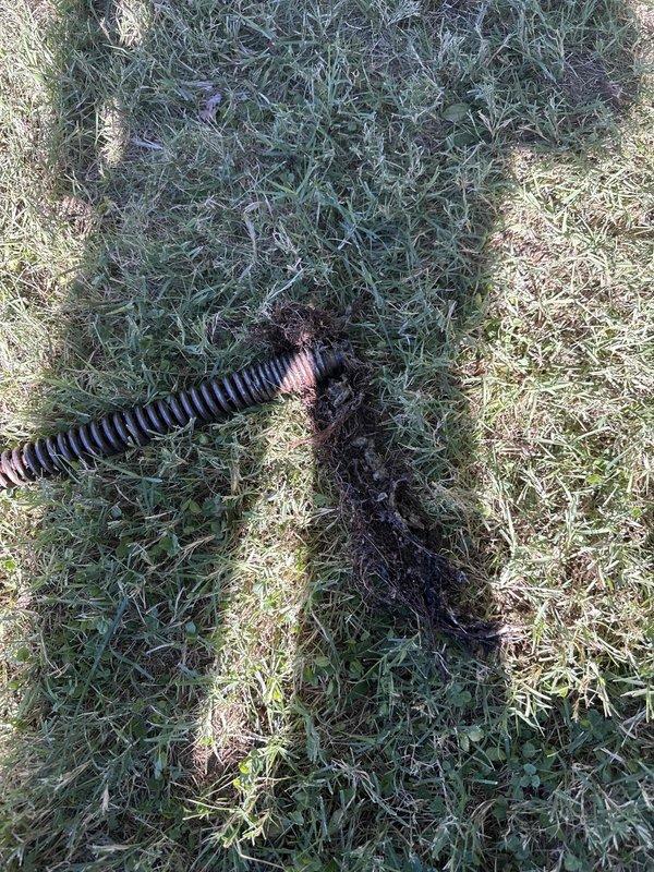 Responded to an emergency sewer line backup and diagnosed a main line blockage caused by root intrusion. Cleared the obstruction using a sewer drain cleaning cable (auger), extracting a mass of tangled roots and debris from the line and restoring full flow, which resolved the toilet drainage issue. Recommend a camera inspection and periodic root maintenance to prevent recurrence.