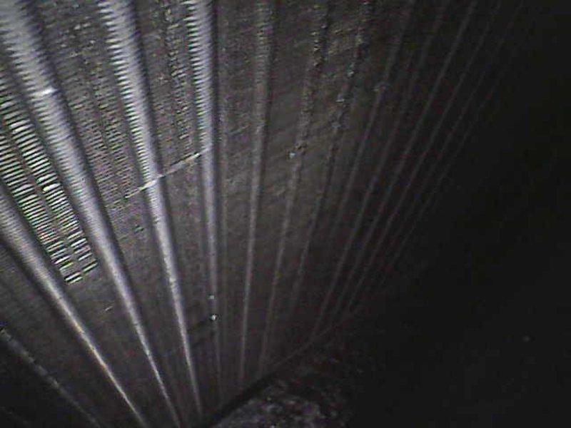 Responded to callback for recurring system error codes. Performed borescope inspection of the refrigerant line and evaporator coil, which revealed dust and grime buildup on the coil fins along with surface corrosion and staining on the tubing, restricting airflow and heat transfer. Cleaned the affected components and verified proper system operation, with error codes cleared.