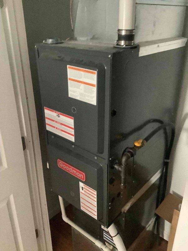 Responded to a no-heat complaint on a split system consisting of an indoor Goodman gas furnace and an outdoor Goodman condenser, where cooling operated normally. Inspection showed the heating source is a gas-fired furnace, not an all-electric heat pump, so the system is a conventional air conditioner and furnace combination; the furnace has an intact gas supply with shutoff valve, PVC vent and drain piping, and no visible corrosion or damage. The outdoor condenser coil was noted to be dirty with debris buildup and leaf accumulation around the pad, and cleaning of the coil and surrounding area is recommended to maintain cooling efficiency.
