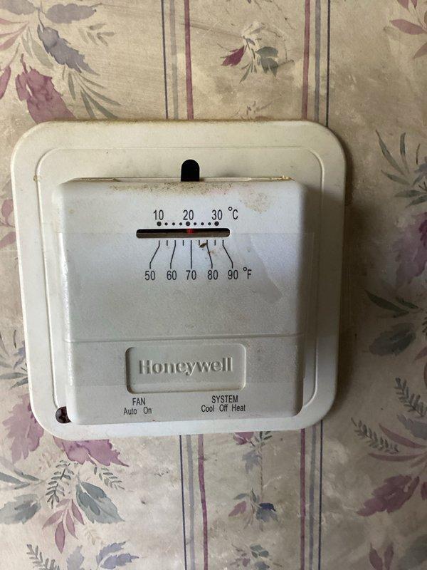 Responded to a no-heat call with no system response at the thermostat. Inspected the Honeywell analog thermostat and the furnace control board, verified 24 VAC control voltage and board operation (status LED illuminated), and noted discoloration on the board near the resistors indicating possible heat stress or contamination. Evaluated the control circuit and relay to determine the cause of the heat call failure.