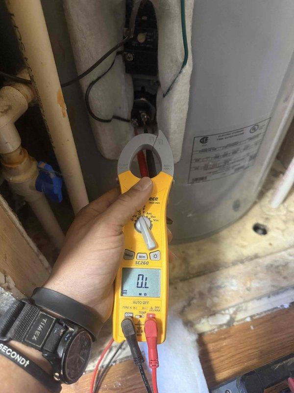 Performed a diagnostic assessment of the electric tank water heater, including electrical testing of the heating element and thermostat circuit with a clamp meter at the exposed access panel. Inspected the adjacent supply piping and valves, noting staining on the pipe near the upper fittings. Measured the furnace room door opening to confirm clearance for replacement equipment.