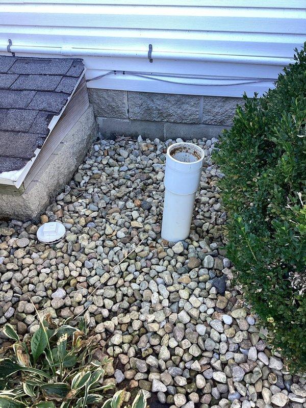 Responded to a flooding downstairs toilet and located the exterior main sewer cleanout, where the open standpipe showed heavy staining and standing sewage, indicating a main drain blockage. Accessed the cleanout to relieve the obstruction and restore proper drainage flow, eliminating the backup at the fixture.