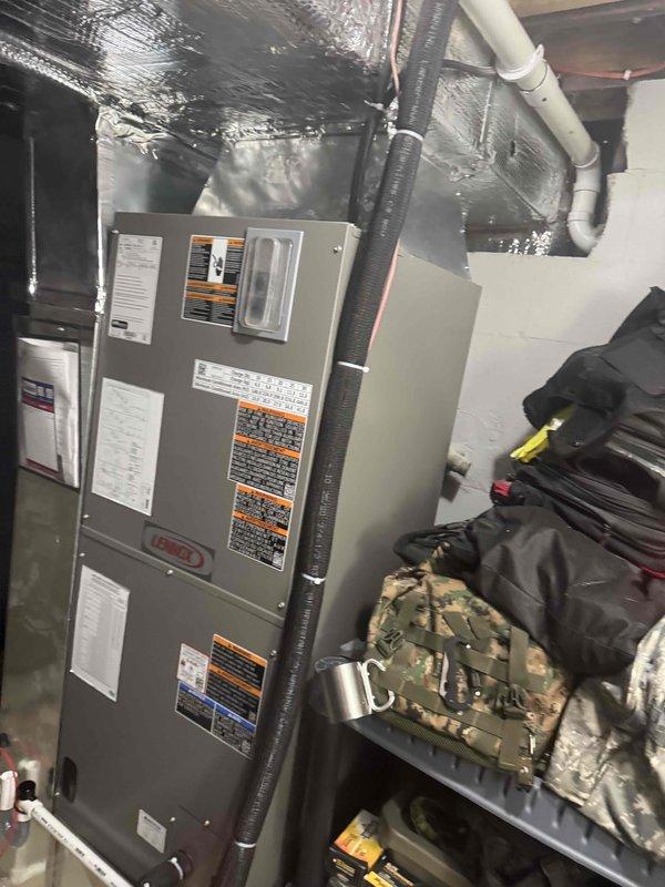 Completed installation of a Lennox heat pump system, including the indoor air handler with insulated flex duct and foil-wrapped supply plenum connections, secured with zip ties, and PVC condensate drain routing with elbow fittings. Installed and configured a Honeywell Home ProSeries digital thermostat, which is operating properly and displaying a 67°F reading. Verified the system showed no signs of frost, rust, or visible damage at completion.