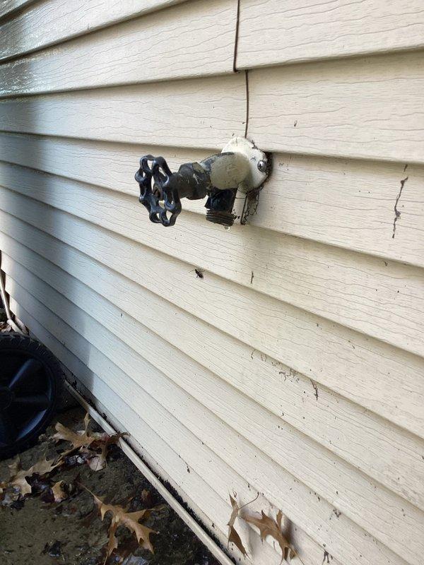 Diagnosed standing water at the front porch as a leak at the exterior hose bib, with moisture present at the spigot and damp soil below. Removed the corroded hose bib and the rusted, corroded supply connections and flexible lines, then installed new fittings and a replacement hose bib to restore a watertight seal. Pressure-tested the line and confirmed no further leakage or water pooling.