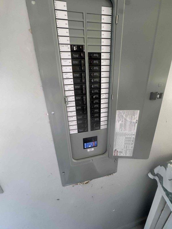 Completed a 200 amp service panel upgrade, installing a new flush-mounted distribution panel with a main breaker and a digital monitoring module, and landing all branch circuits on properly sized breakers. Circuits were identified with handwritten directory labels and the panel schedule was posted inside the door. Wall cutouts were opened to set the enclosure, with surrounding drywall and insulation left exposed for patch and finish work.