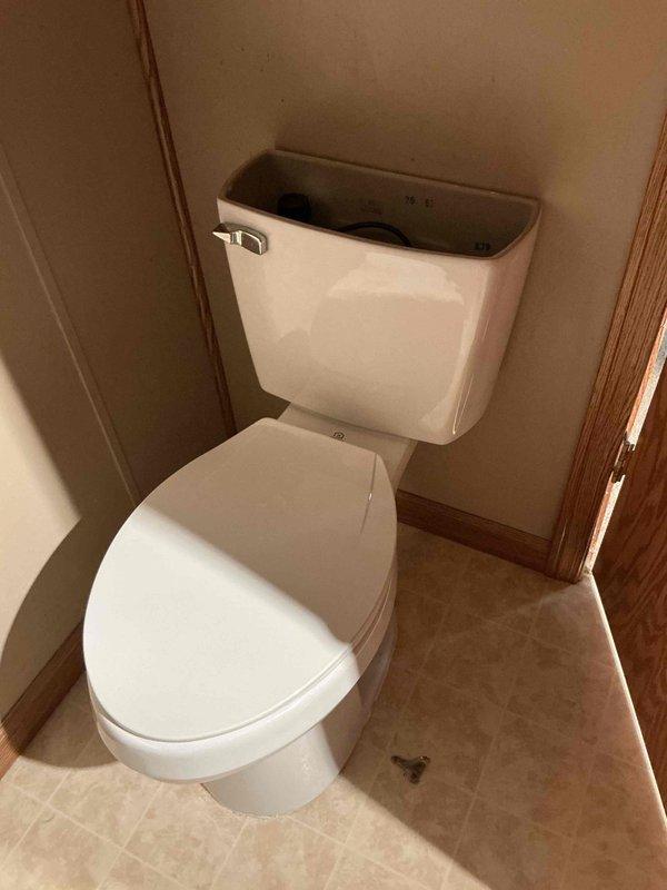Responded to a callback for a newly installed two-piece toilet reported to be leaking and inspected the unit, including the open tank and internal fill and flush components. Diagnosed the source of the leak, corrected the issue, and tested the toilet through multiple flush cycles to confirm proper operation with no further leakage.