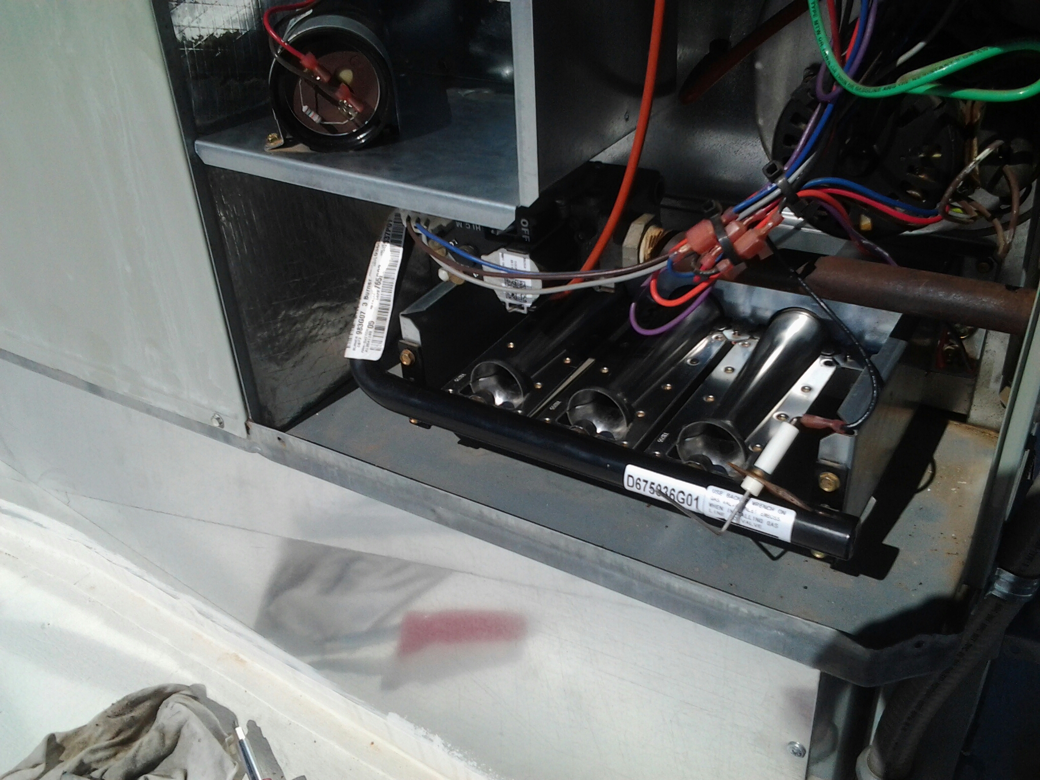 Cleaning a temperature flame sensor and burner assembly on a routine heating season maintenance