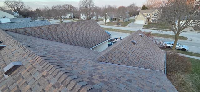 This project in Waukesha centered around specialized metal fabrication and a ventilation transformation for both the home and attached garage! Along with installing a high-performance CertainTeed NorthGate ClimateFlex Class 4 impact-rated shingle system in Heather Blend, we focused on solving unique roofline challenges. Our crew removed the existing power vent, added 12 new brown slant-back roof vents to optimize ventilation, and carefully worked around the existing B-vent and three plumbing stacks with lifetime silicone boots. The highlight of the restoration was the custom chimney work: we detached the surrounding siding to run a six-foot ice and water shield barrier, built a custom 26-gauge coated steel cricket, carefully reinstalled the original siding, and fitted the chimney with a brand-new 24-gauge steel cap. To finish it off, we protected the roof deck with painted "W" style galvanized valley metal and preserved the home's existing gutter system for a seamless, heavy-duty upgra