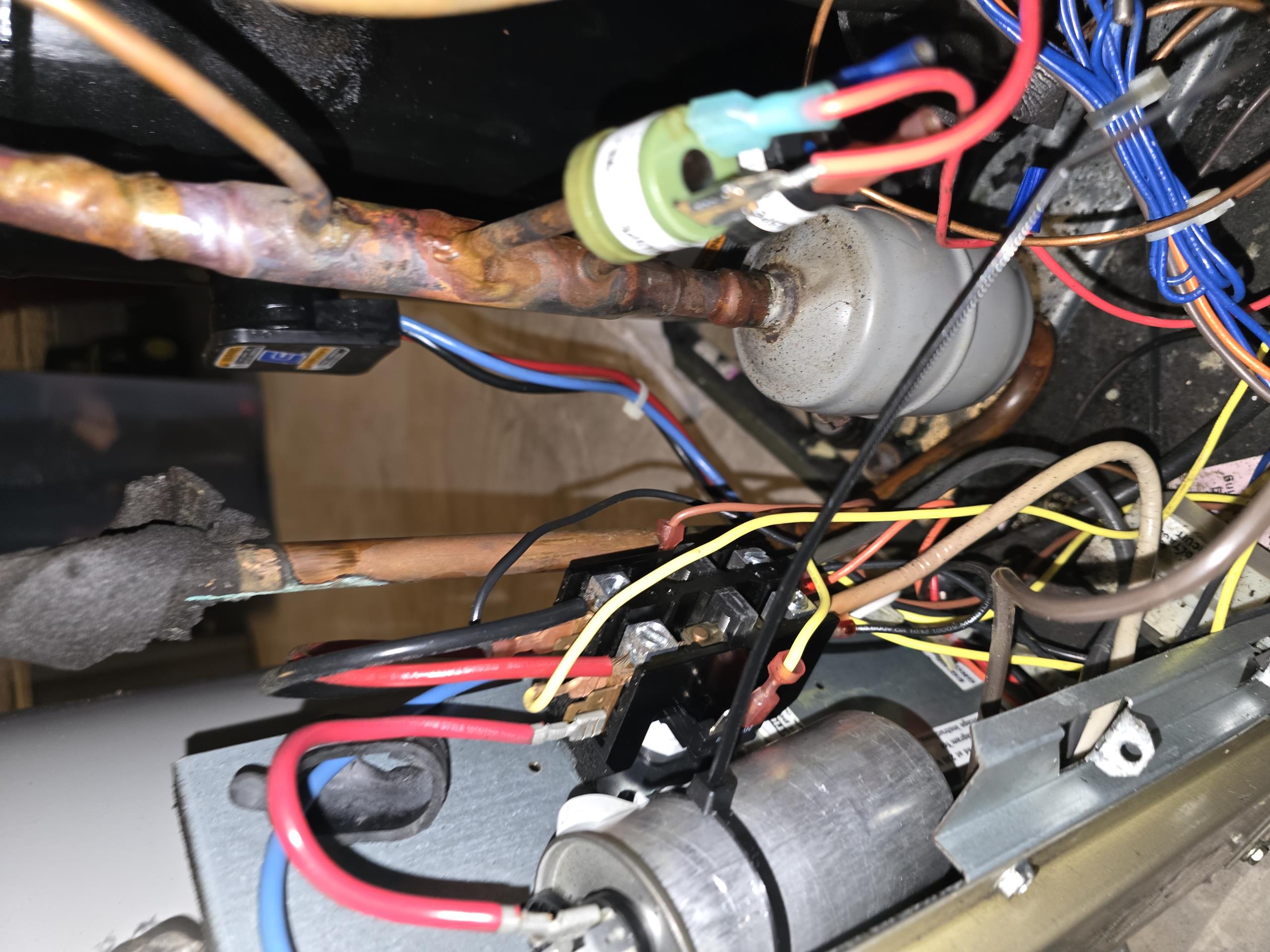 Upon arrival, system is in emergency heat mode for heating. There is an audible refrigerant leak when the door is taken off. Located refrigerant leak on a bend in the pipe just after the filter drier. The leak is a micro crack in the copper joint. Inspected area of leak and fund a sufficient amount of black residue matching the consistency and smell of acidic refrigerant oil commonly seen with a burned out compressor. With the recent compressor replacement, is is suspected that the refrigerant had been contaminated and the acidic oil has been eating away at the copper. 

Other issues found with the system include bypassed safety switches, burned wires, and an incorrectly plumbed hot water generator. There is also some kind of water in the bottom along the coaxial heat exchanger that could be evidence of a leaking coaxial heat exchanger but could not verify as the ground loop solution is unable to be distinguished between glycol or alcohol solutions.

Due to current and past refrigerant