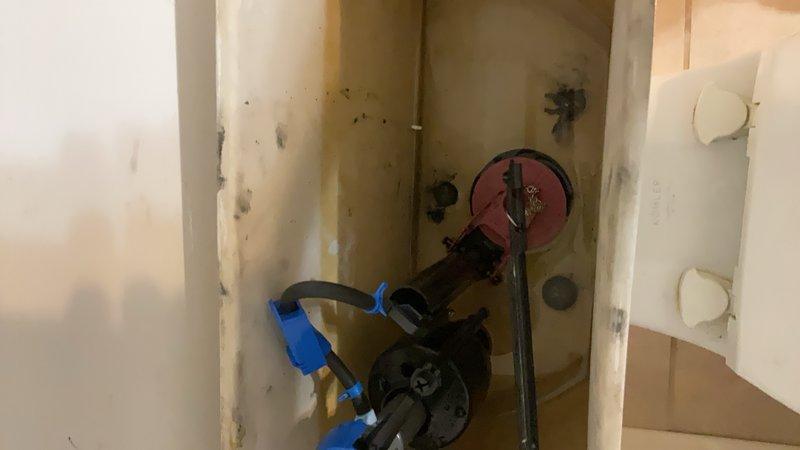Responded to plumbing leak investigation and inspection at residential property. Upon arrival, accessed wall cavity through existing access panel to assess water supply system and identify source of moisture damage. Documented extensive water staining on interior drywall surfaces with visible discoloration patterns indicating active or recent water intrusion from plumbing components. Inspected exposed copper supply lines, shut-off valves, and main water control valve within wall cavity. Observed evidence of mold or mildew growth on drywall surfaces consistent with prolonged moisture exposure. Photographed conditions for documentation purposes including KOHLER toilet fixture and compromised wall areas. Recommend immediate remediation of water-damaged drywall, mold treatment, and further evaluation of plumbing connections to prevent future water intrusion.
