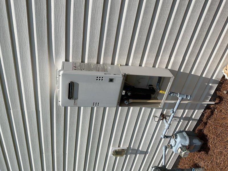 Performed diagnostic inspection of residential HVAC system and associated components. Evaluated pressure readings on outdoor equipment using calibrated gauge to verify system operating parameters were within manufacturer specifications. Inspected exterior-mounted air handler unit, examined internal wiring and components through access panel, and confirmed proper ventilation through top and bottom grilles. Verified gas meter installation and connection integrity, checked PVC condensate drain lines for proper routing and secure mounting along building exterior. All equipment found to be functioning properly with no immediate service needs identified.