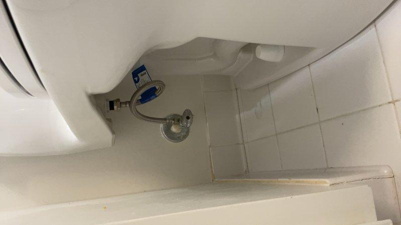 Responded to plumbing service call for toilet tank water supply issue. Upon inspection, found deteriorated fill valve assembly with worn float mechanism requiring replacement. Removed existing chrome-plated fill valve and installed new unit with proper water supply connections. Addressed secondary concern of ceiling water damage around bathroom exhaust or plumbing penetration, evidenced by extensive brown staining and discoloration on white tile surface surrounding circular opening. Damage pattern indicated chronic moisture intrusion from above fixture. Documented conditions for further remediation recommendations. Tested toilet fill valve operation and verified proper water flow and shutoff function. System restored to normal operation.