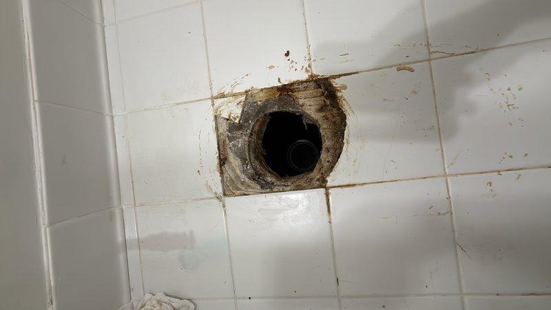 Responded to plumbing service call for toilet tank water supply issue. Upon inspection, found deteriorated fill valve assembly with worn float mechanism requiring replacement. Removed existing chrome-plated fill valve and installed new unit with proper water supply connections. Addressed secondary concern of ceiling water damage around bathroom exhaust or plumbing penetration, evidenced by extensive brown staining and discoloration on white tile surface surrounding circular opening. Damage pattern indicated chronic moisture intrusion from above fixture. Documented conditions for further remediation recommendations. Tested toilet fill valve operation and verified proper water flow and shutoff function. System restored to normal operation.