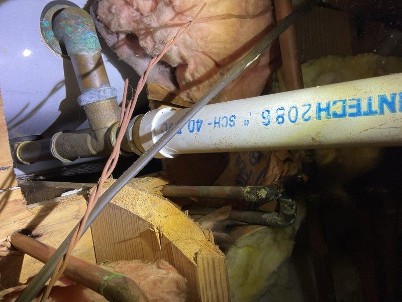 Inspected and documented plumbing system components in attic crawl space, including PVC drainage lines, copper supply piping, and associated fittings and connections. Verified proper installation and current condition of pipe joints, insulation materials, and structural support elements within the confined utility space.
