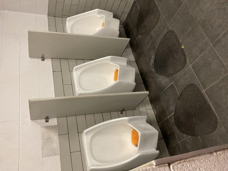 Performed routine commercial restroom maintenance and cleaning service. Serviced three wall-mounted urinals with fresh deodorizer blocks and cleaned fixtures to maintain sanitary conditions. Mopped and sanitized tile flooring in both the urinal area and adjacent toilet room, addressing water spots and high-traffic wear patterns. Inspected and wiped down all porcelain fixtures, wall-mounted flush valves, and surrounding surfaces including vanity countertop and drain fixtures. All restroom facilities left in clean, operational condition meeting commercial hygiene standards.