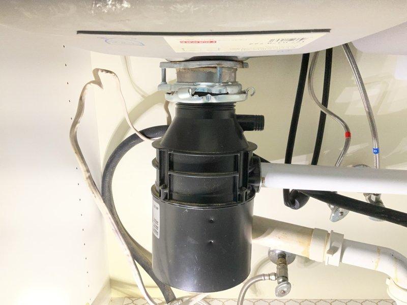 Plumber recommended under-sink plumbing repair including P-trap assembly, drainage components, water supply lines, and garbage disposal unit.