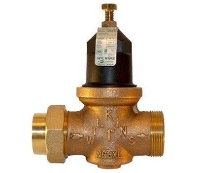 Installed new pressure reducing valve and copper plumbing fitting to regulate water pressure in the residential plumbing system. The brass pressure reducing valve with adjustable control mechanism was positioned to ensure proper flow direction, and a copper barbed connector fitting was installed to complete secure hose connections within the system.