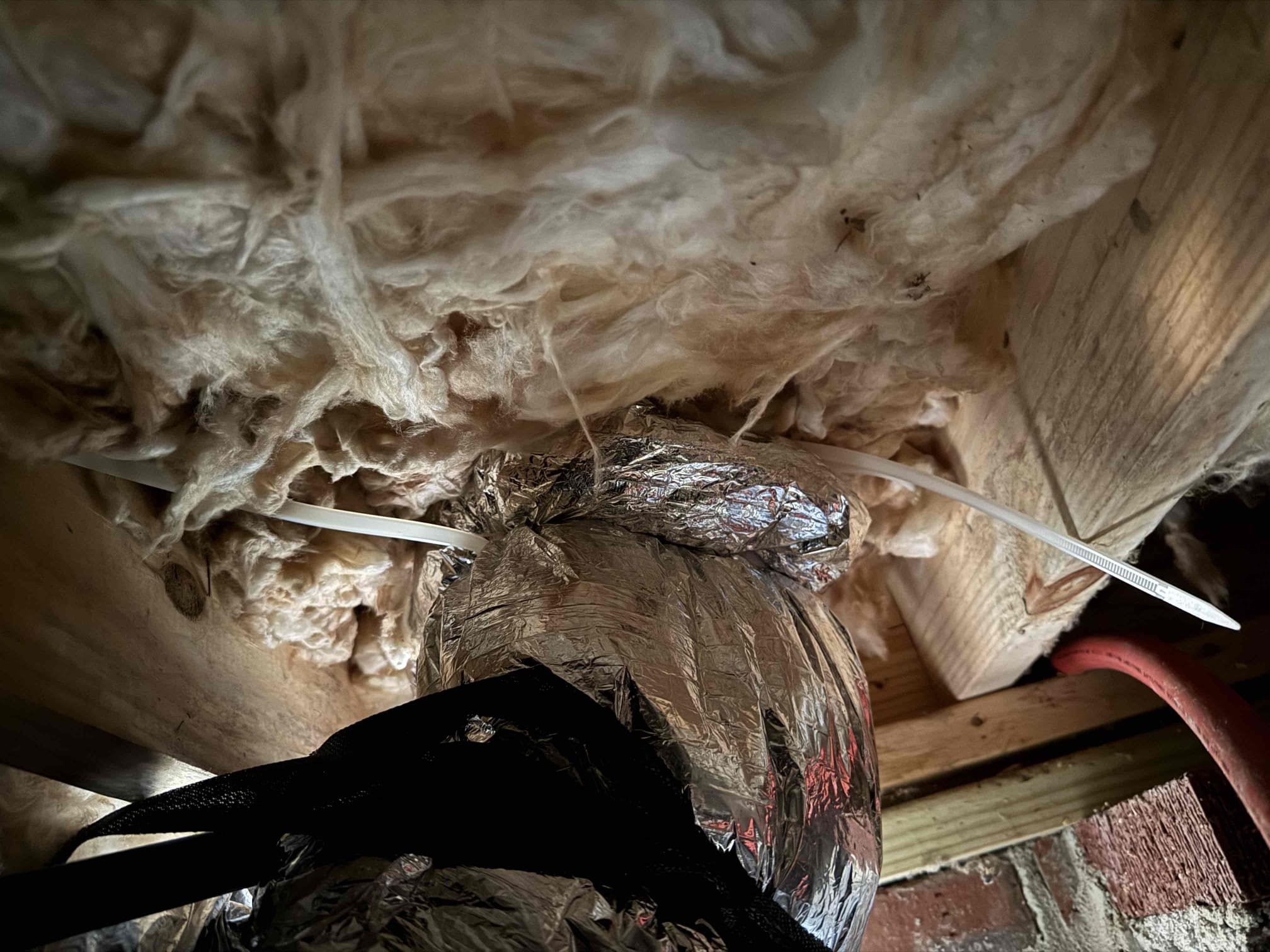 
Repairing the end of the flex run good enough to repair without replacing the full run. This was almost inaccessible due to how low the crawlspace is on the front corner of the house, but ensuring proper secure and seal of the 6 inch flex run to the boot of the supply vent. Screws straps and tape was used. Please note that it looks like plumbers. Just literally jerked it out of their way tearing the end of the flex run off and leaving it sealed to the boot. Everything had to be removed in the end of the flex repaired before connection.