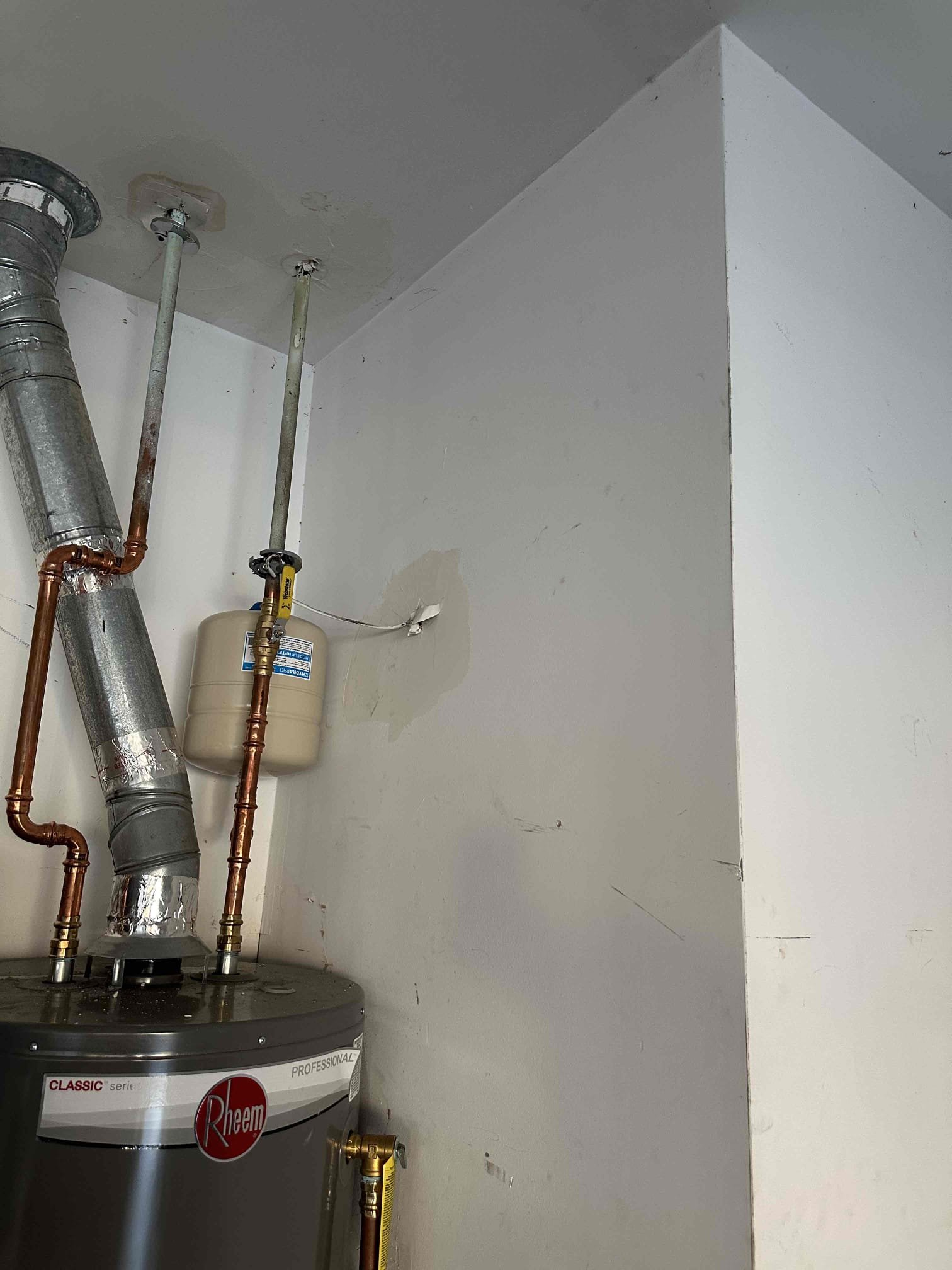 We arrived at the call, found a very restricted drain line was able to blow it out with high pressure nitrogen. We had to cap off the tea because it was only being held by tap which made it leak in the first place. Because it wasn’t a proper seal. And the bottom of the pan secondary drain was only held by caulk. We replaced it with a T and kept it off with glue. They kept off the tee with PVC and a cap and put in a union. Also put a bull frog safety switch in the drain pan.
System is now up and running
////
Damage done to the garage side, but still Sheetrock. On the ceiling above water heater. 