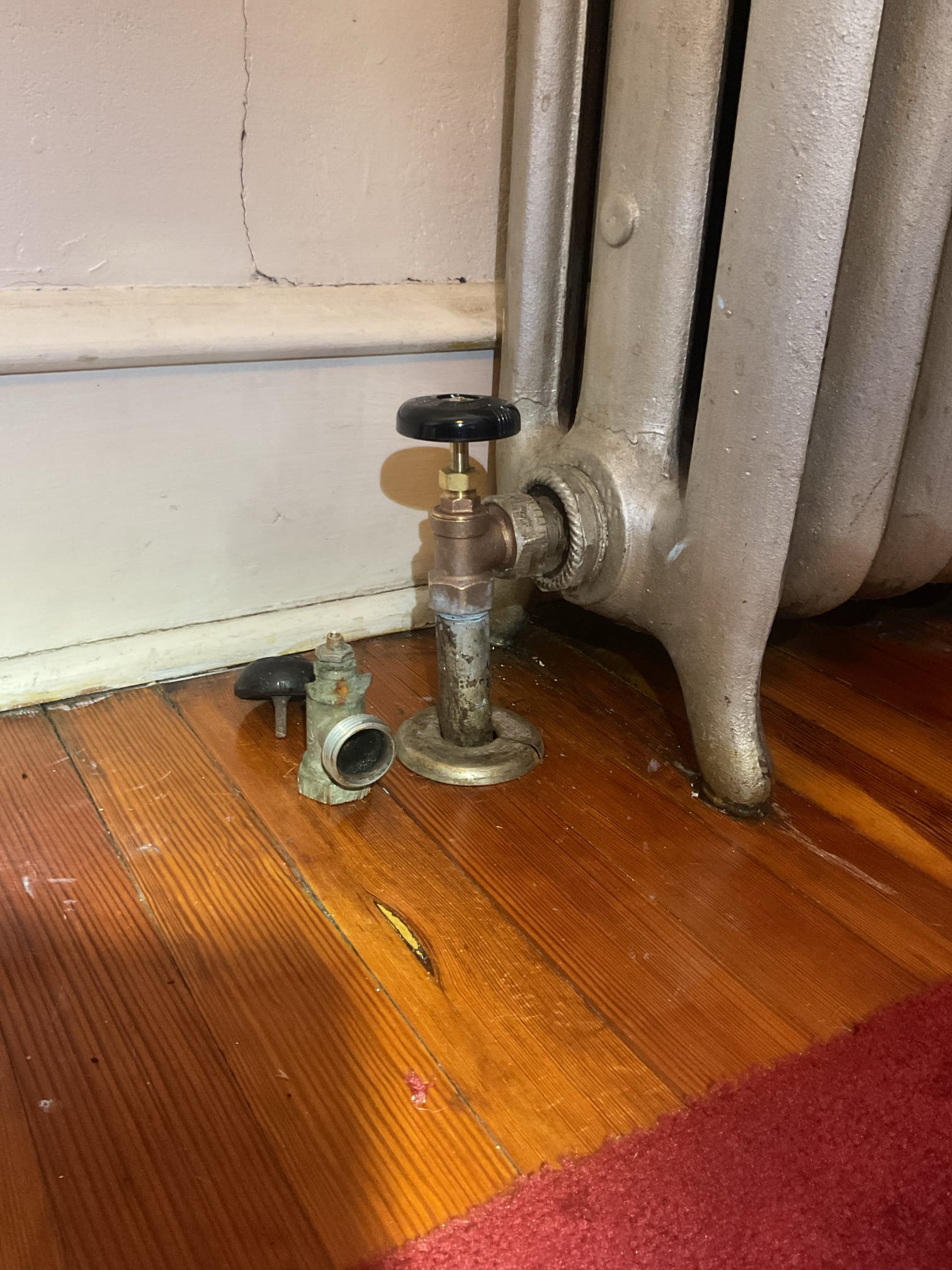 Relieved pressure from boiler.
Unthreaded unions on problem radiator both sides.
Unfortunately the radiator had 8 gallons of water still in it. Gradually drained radiator into small containers until nearly empty. 
Removed old valve.
Installed new valve with thread tape and pipe dope.
Reinstalled boiler in place and tightened unions.
Pressurized boiler. Bled all radiators and tested.

Couldn’t stay long enough to wait for problem radiator to get to temp but it is bled of air.
I told her to keep the thermostat on to allow boiler to come back to temp.
Left estimate to install new 1/2” boiler feed valve. Current valve is a gate valve with slight leak at packing nut.

She paid balance today. 

Todays problem radiator may be controlled by the thermostat labeled “apartment”