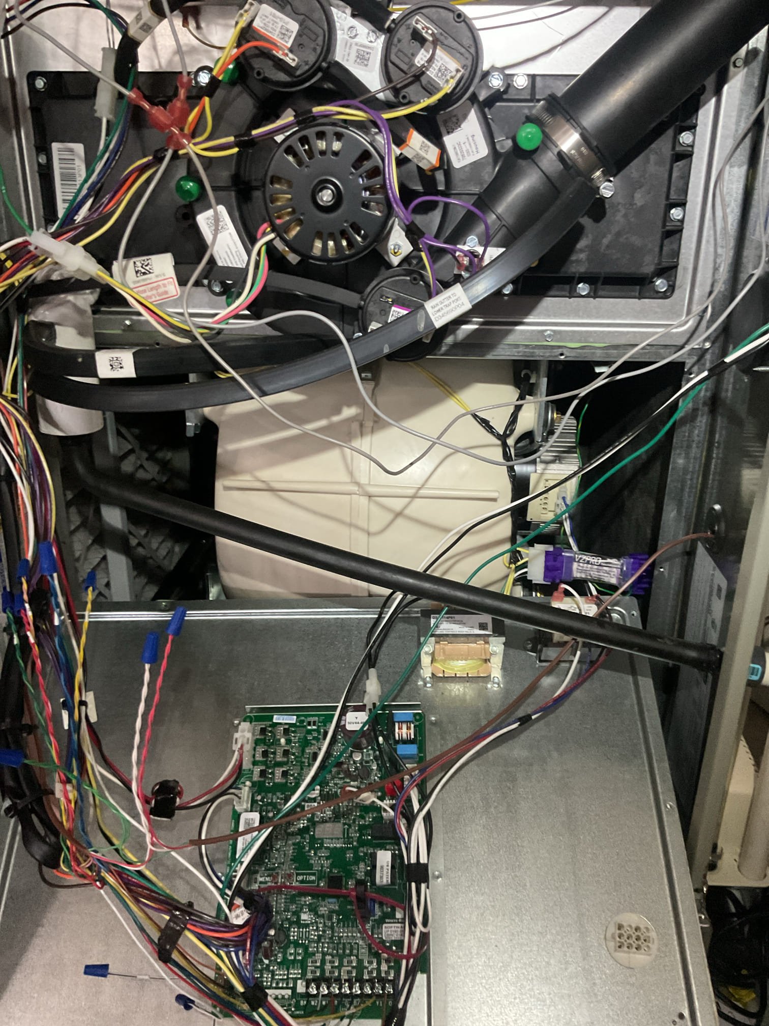 Issue is a “burning smell” 
To me it smells something like burnt candles.
Humidity in basement is also high, smell is more pronounced in the basement itself. 
The plug in dehumidifier may not be working. He will allow it to run and see if it fills the bucket. 

I opened blower compartment of furnace and inspected blower motor, surge protector and harness. No burning smells or indication of overheating.
Also opened high voltage junction box and receptacle and switch. No burned components or overheated wires. Checked the Arzel panel as well. No odors or overheated wires.

There is a hybrid water heater. Filter was a little dirty. We cleaned and put back and opened hot water faucets to get water heater to run. Also checked all wiring connections there. 
To me there is a slight odor on the discharge of water heater. The compressor of the water heater also sounds abnormal/noisy.

The odor is not coming from HVAC equipment. I believe it’s related to humidity in basement. 
