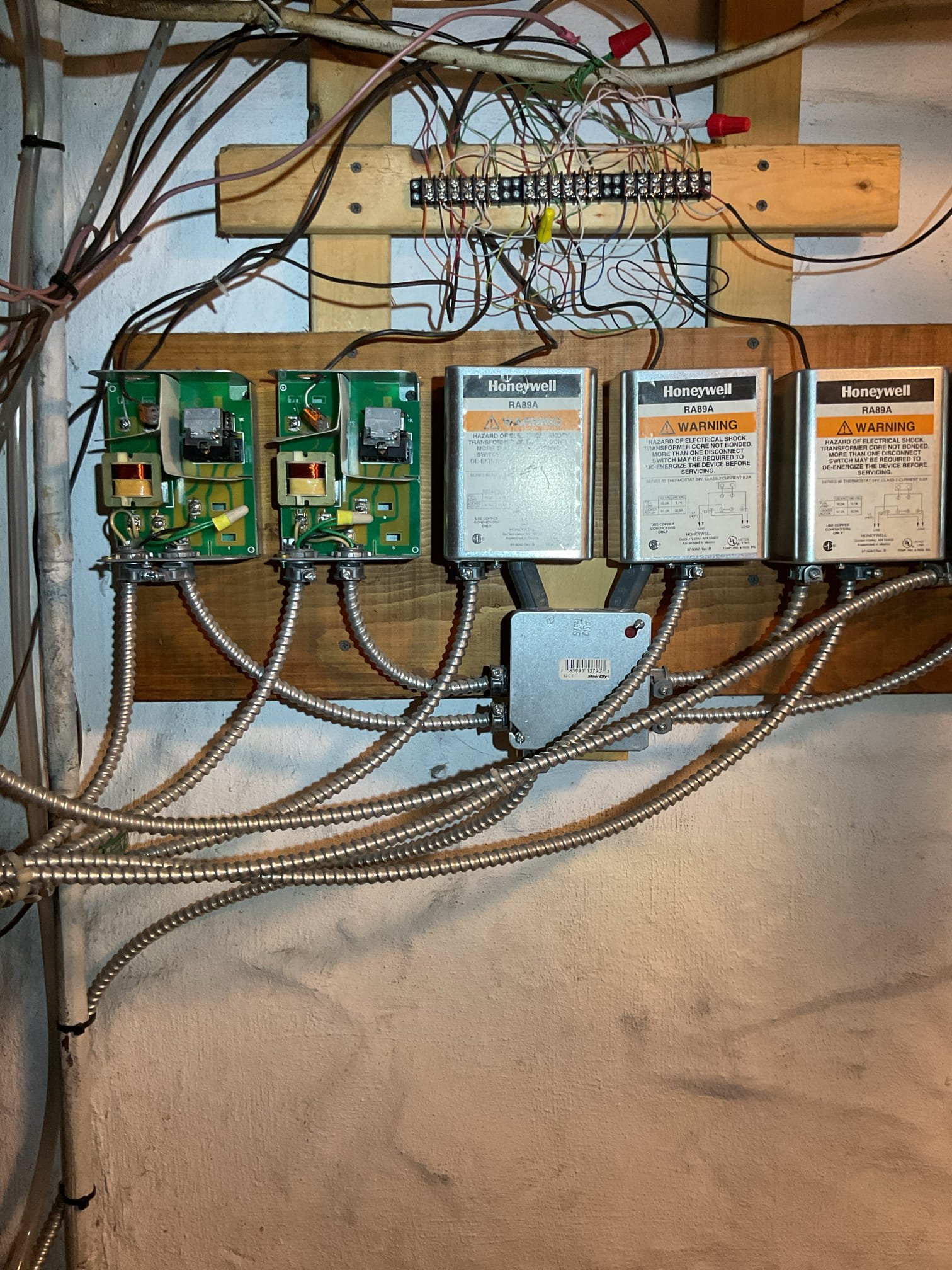 When I arrived and tuned boiler on I found 13 volts between TT on each of (6) relays. And relays were chattering. 
Relays are shut or partially shut for each zone even if there is no demand for the thermostats. Even when wires are taken out of thermostats altogether I was still measuring 0V between T T contacts. 

Unfortunately I couldn’t resolve the issue.
I took one wire out of TT at each relay to stop the chattering for now. 
Need to schedule a return. 

Also set warm weather shutdown to 72° Meaning boiler will not operate fo space heating if outdoor temperature is 72° or higher.n
