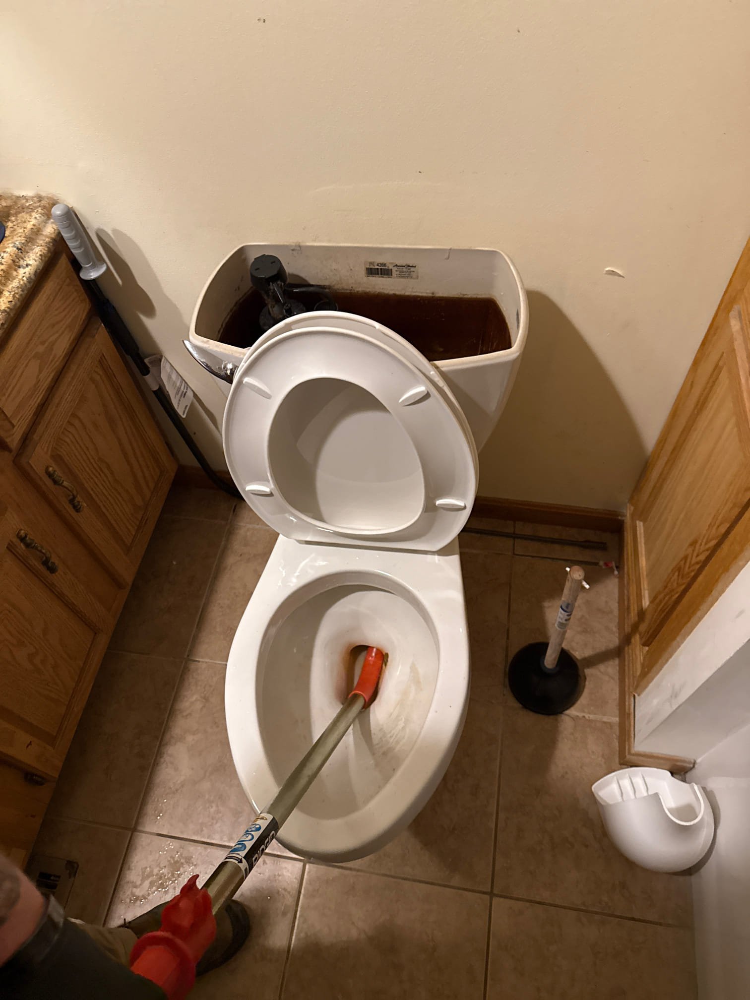 Run toilet auger through the toilet to try and clear blockage. 